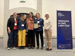 Jennifer Hashley and her team receiving an award from Laurie Wolinski